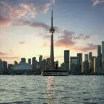 Stunning Toronto skyline at sunset, highlighting the CN Tower and waterfront from Lake Ontario.